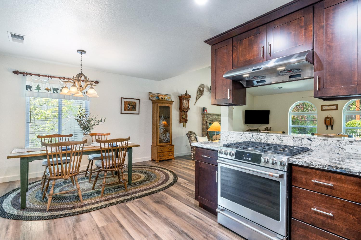 39398 Robin Bass Lake, CA 93604 - Photo 12 of 31 a kitchen with stainless steel appliances granite countertop a stove a chimney a dining table and chairs