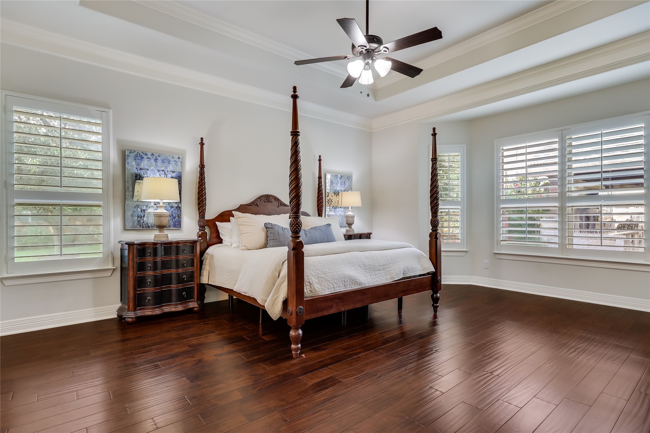 401 Bluff View Road Cedar Park, TX 78613 - Photo 33 of 40 Rich hardwood flooring complements a spacious bedroom featuring a classic four-poster bed and decorative tray ceiling.