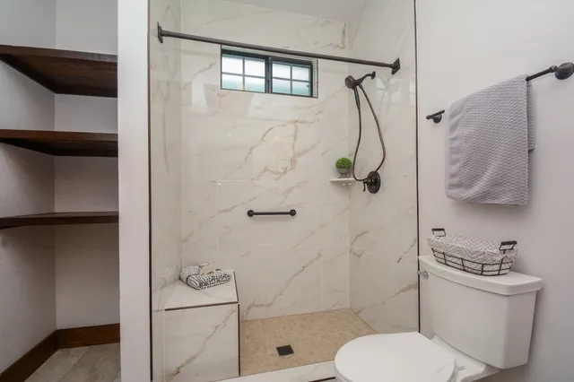 a bathroom with a toilet and a shower