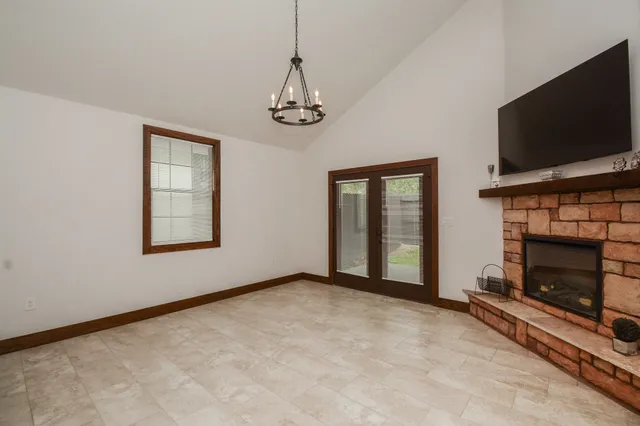 a view of an empty room with window and fireplace