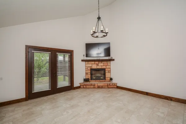 a view of a livingroom with a fireplace a ceiling fan and windows