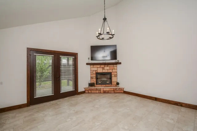a view of a livingroom with a fireplace a ceiling fan and windows