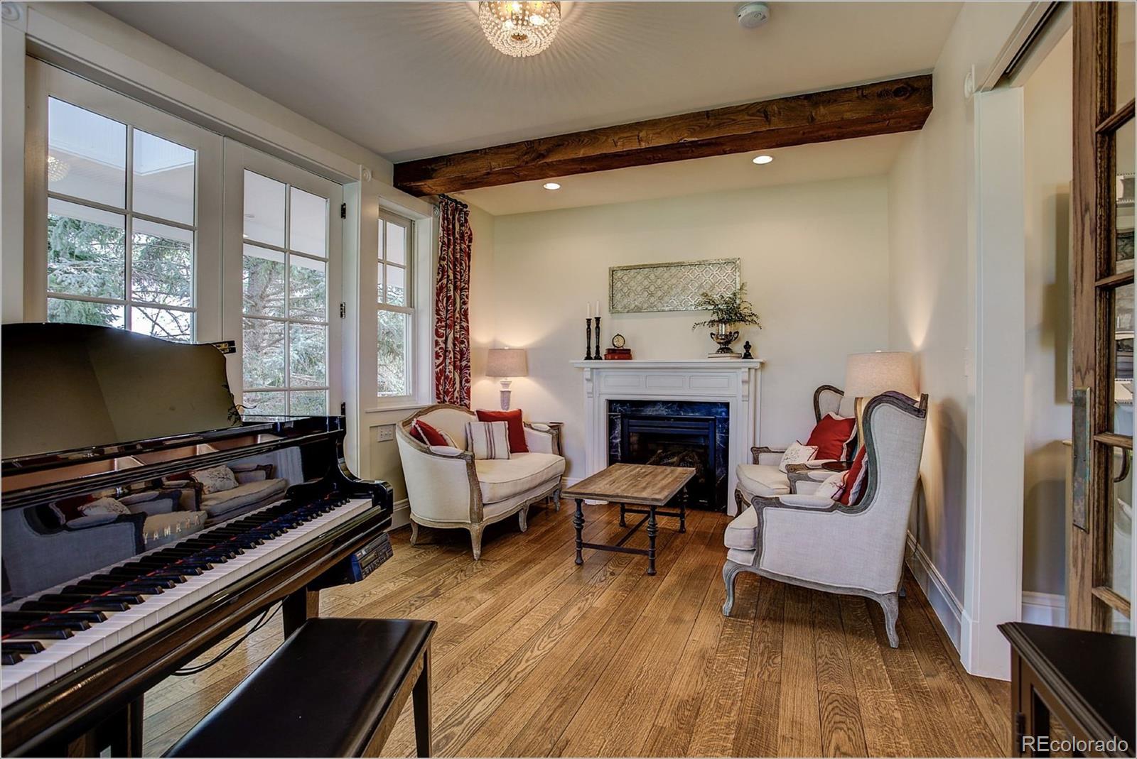 10261 Arapahoe Road Lafayette, CO 80026 - Photo 22 of 35 a living room with furniture a flat screen tv and a fireplace