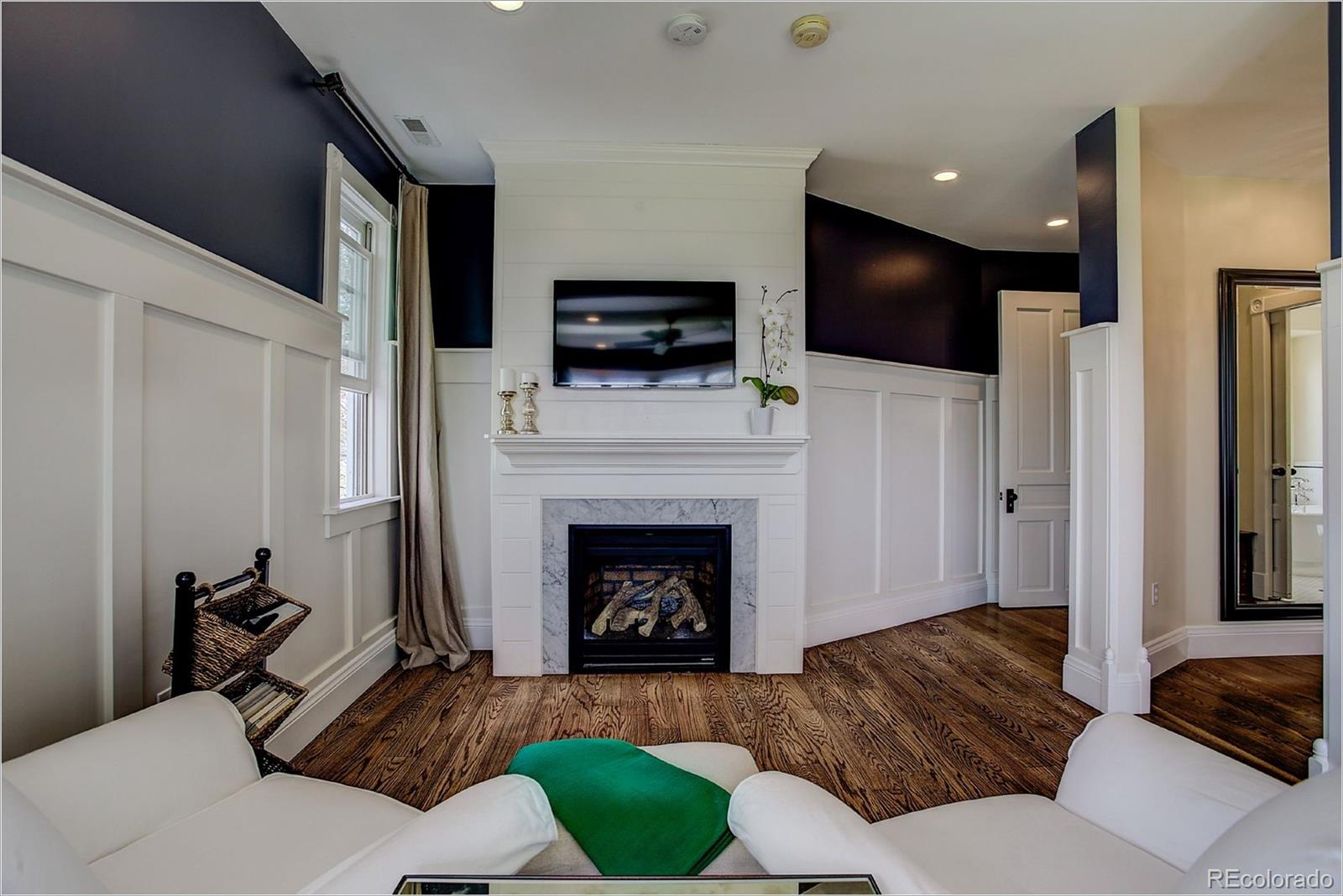 10261 Arapahoe Road Lafayette, CO 80026 - Photo 23 of 35 a living room with furniture a flat screen tv and a fireplace