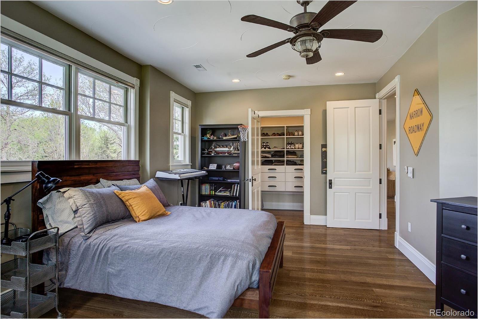 10261 Arapahoe Road Lafayette, CO 80026 - Photo 27 of 35 a bedroom with a bed and wooden floor