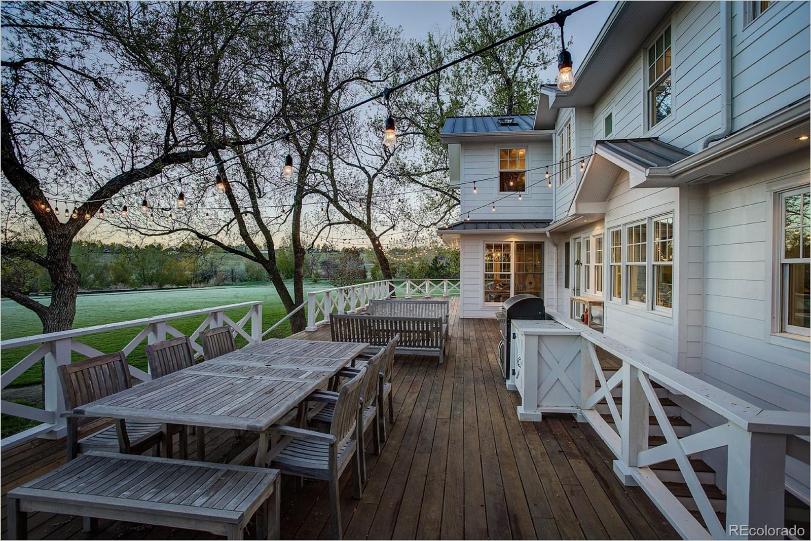10261 Arapahoe Road Lafayette, CO 80026 - Photo 4 of 35 a view of a patio with table and chairs a barbeque with wooden floor and fence