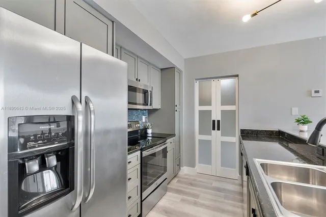 a kitchen with stainless steel appliances granite countertop a refrigerator and a sink