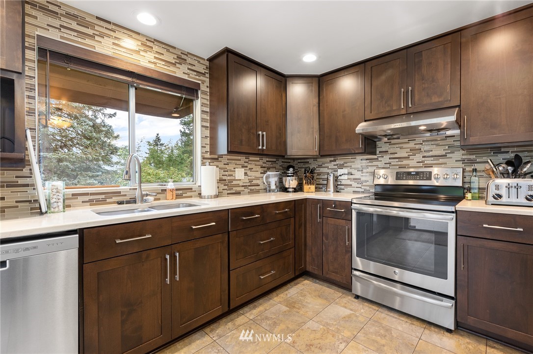 22230 5th Place West Bothell, WA 98021 - Photo 7 of 34 a kitchen with stainless steel appliances granite countertop a sink stove and cabinets