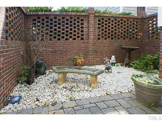 1172 Harp Street Raleigh, NC 27604 - Photo 22 of 25 Sitting area in the enclosed patio with lattice brick fence. Back Yard