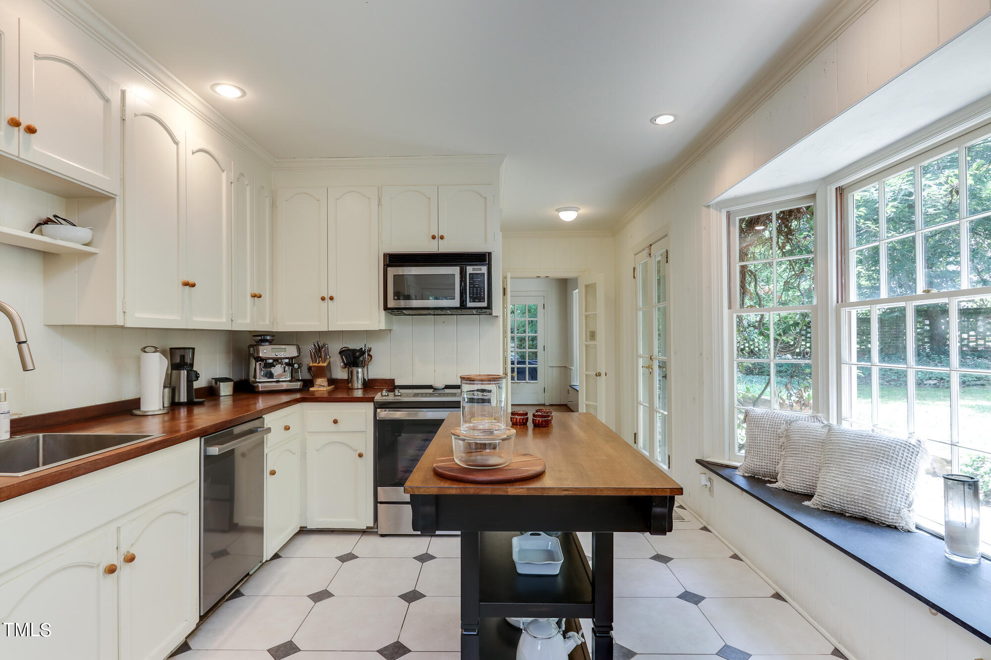 3231 Sussex Road Raleigh, NC 27607 - Photo 12 of 33 a kitchen with a sink a stove a refrigerator and cabinets