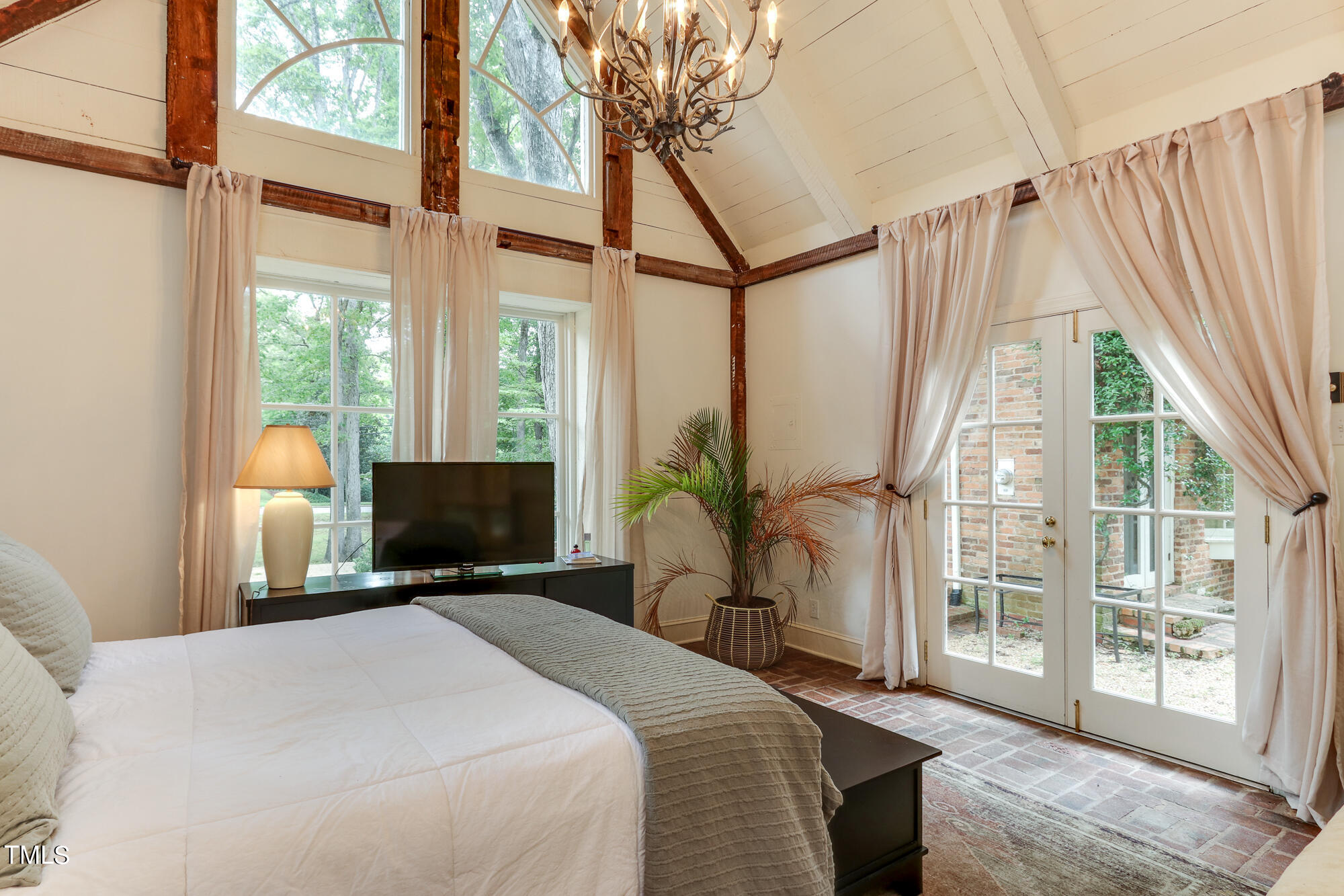 3231 Sussex Road Raleigh, NC 27607 - Photo 23 of 33 a bedroom with a bed a table and flat screen tv