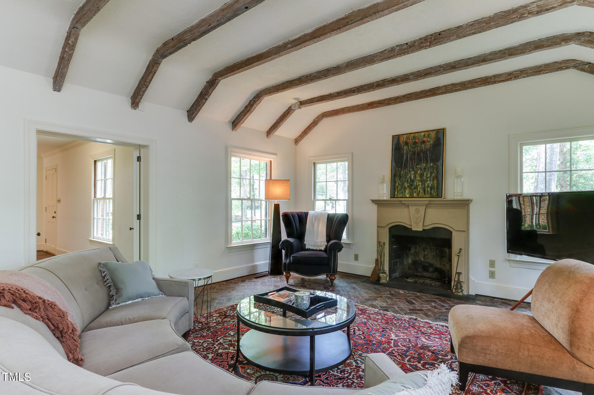 3231 Sussex Road Raleigh, NC 27607 - Photo 7 of 33 a living room with furniture a fireplace and a flat screen tv