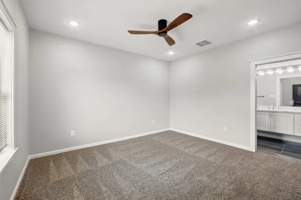 an empty room with a ceiling fan and window