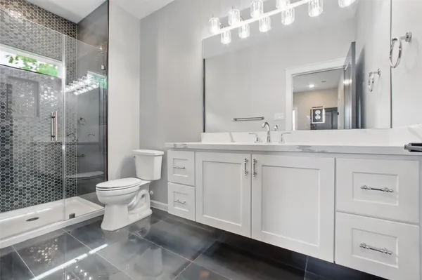 a bathroom with a double vanity sink toilet and shower