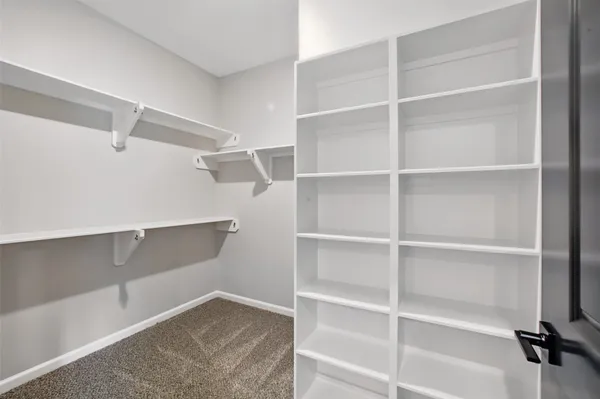 a view of walk in closet with empty racks