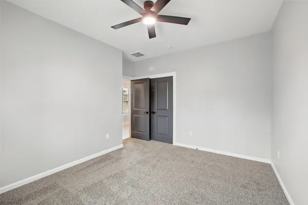 a view of an empty room with a ceiling fan