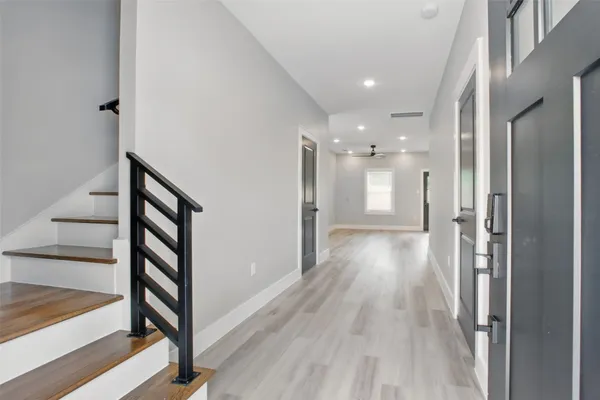 a view of a hallway with wooden floor and staircase