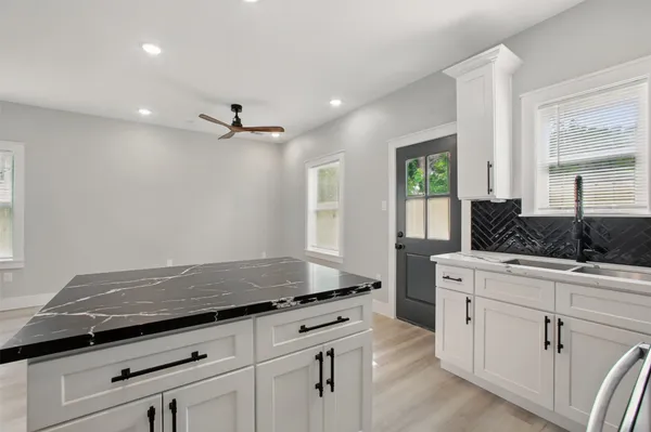 a kitchen with granite countertop a stove cabinets and window