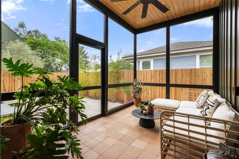 a balcony with chairs and a potted plant