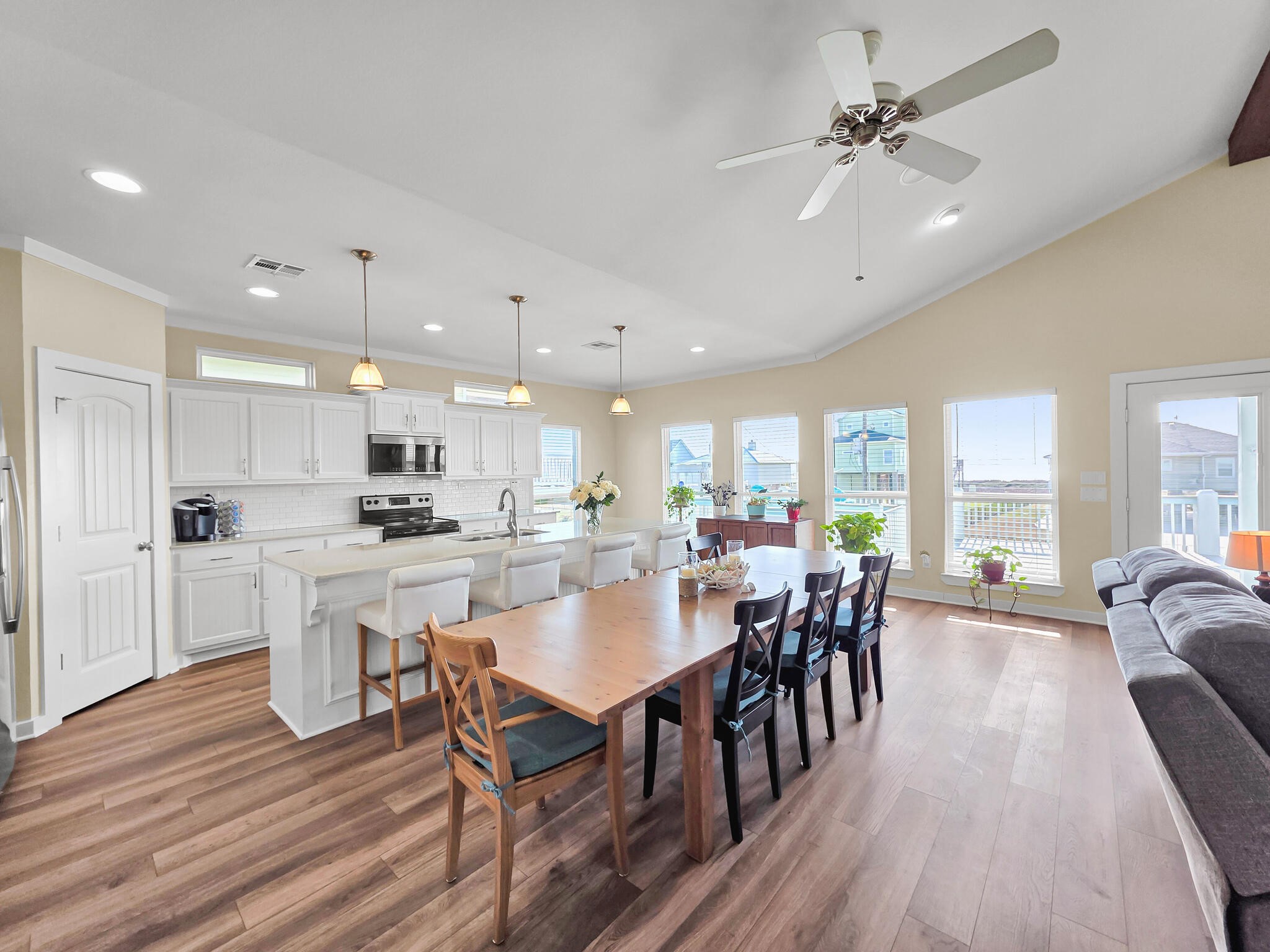 353 Atkinson Street Crystal Beach, TX 77650 - Photo 19 of 42 a large white kitchen with lots of counter space dining table and chairs
