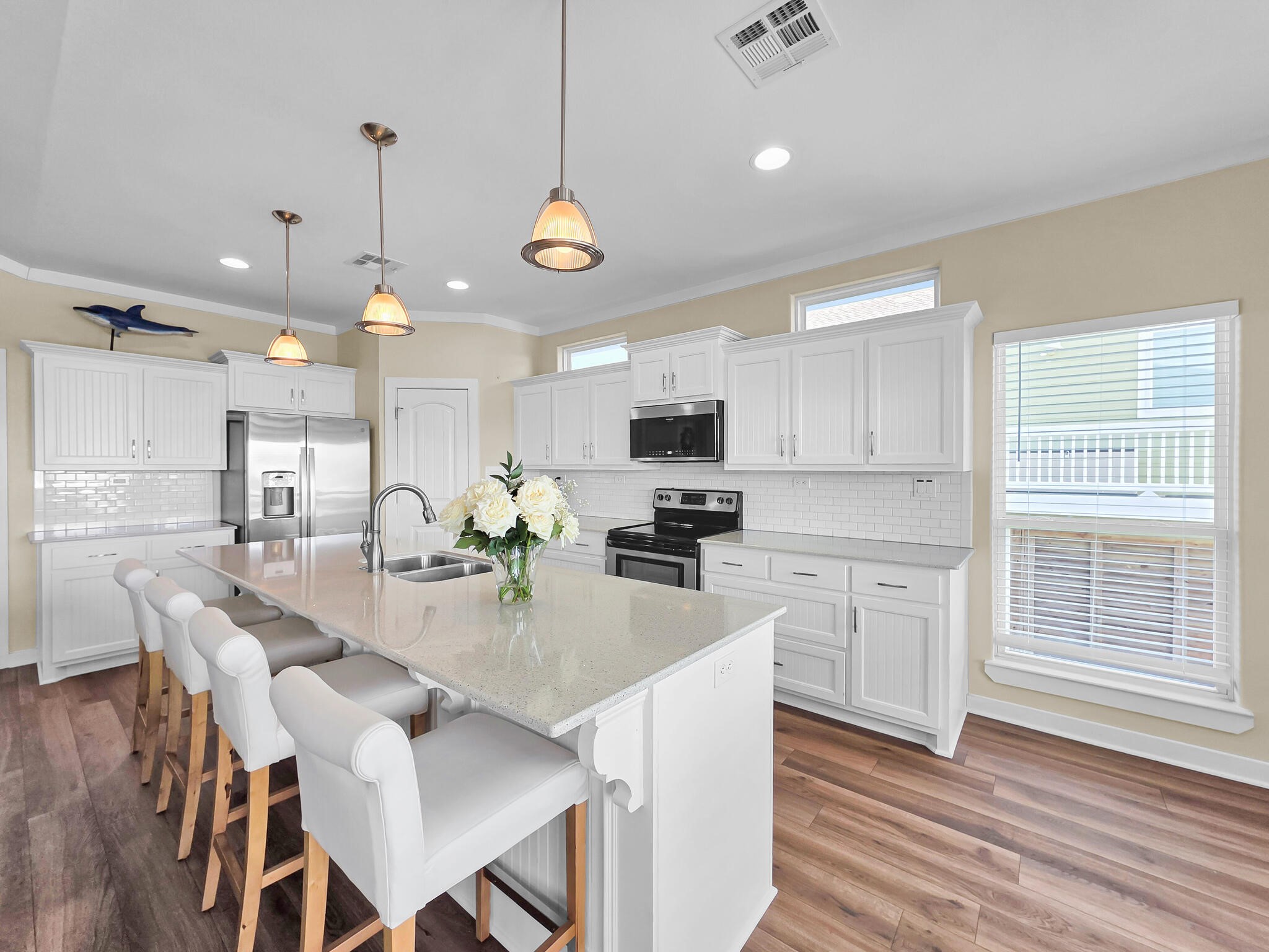353 Atkinson Street Crystal Beach, TX 77650 - Photo 24 of 42 a kitchen with stainless steel appliances kitchen island granite countertop a stove a refrigerator a sink a dining table and chairs with wooden floor