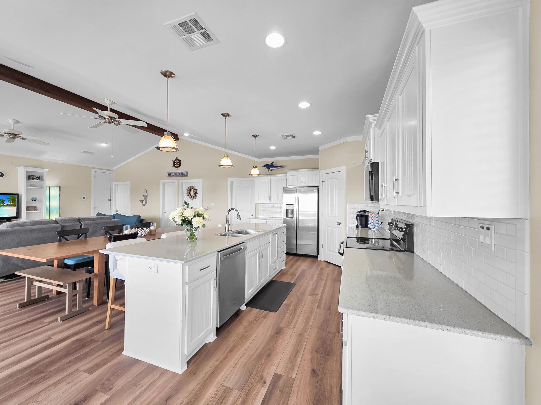 353 Atkinson Street Crystal Beach, TX 77650 - Photo 25 of 42 a large white kitchen with lots of counter space dining table and chairs