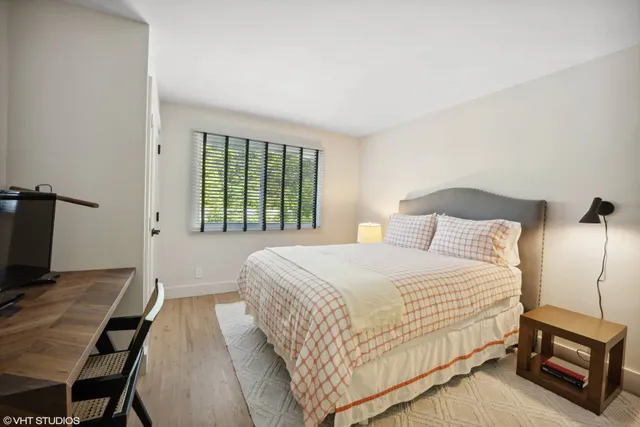 a bedroom with a bed a flat screen tv and a bookshelf