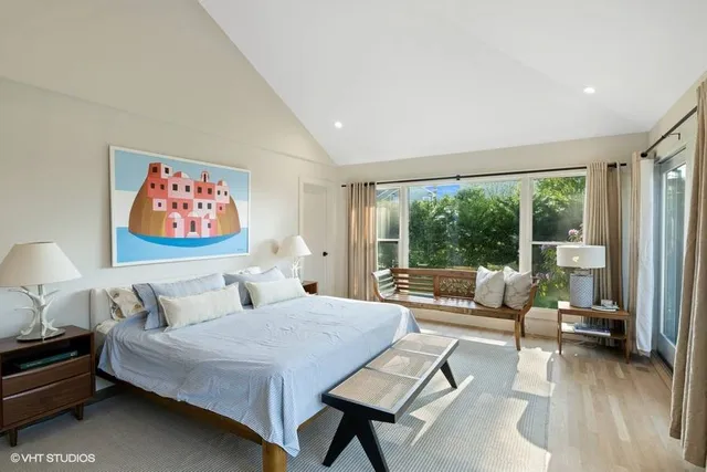 a bedroom with a bed and glass walk in closet