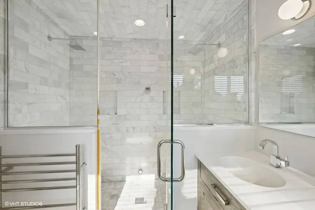 a bathroom with a sink shower and a mirror