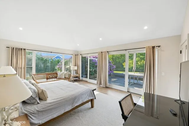 a bedroom with furniture and a large window