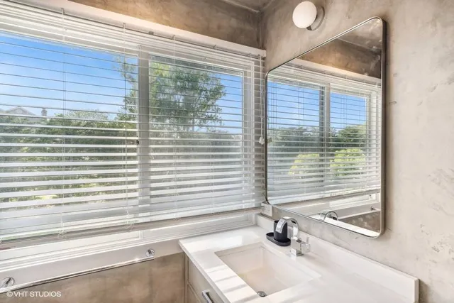 a bathroom with a sink a window and a shower