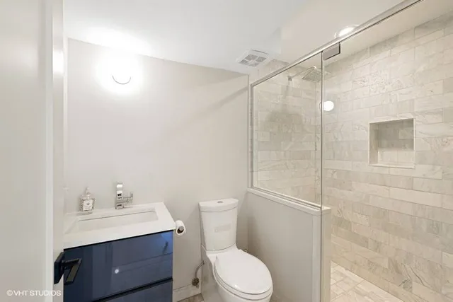 a bathroom with a toilet a sink a mirror and vanity