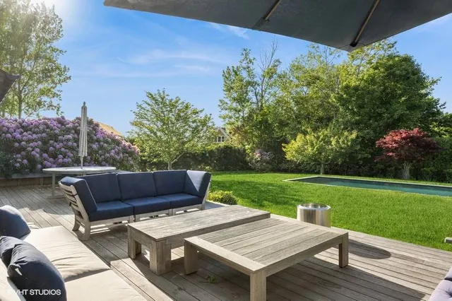 a view of a wooden dinning table and chairs in patio