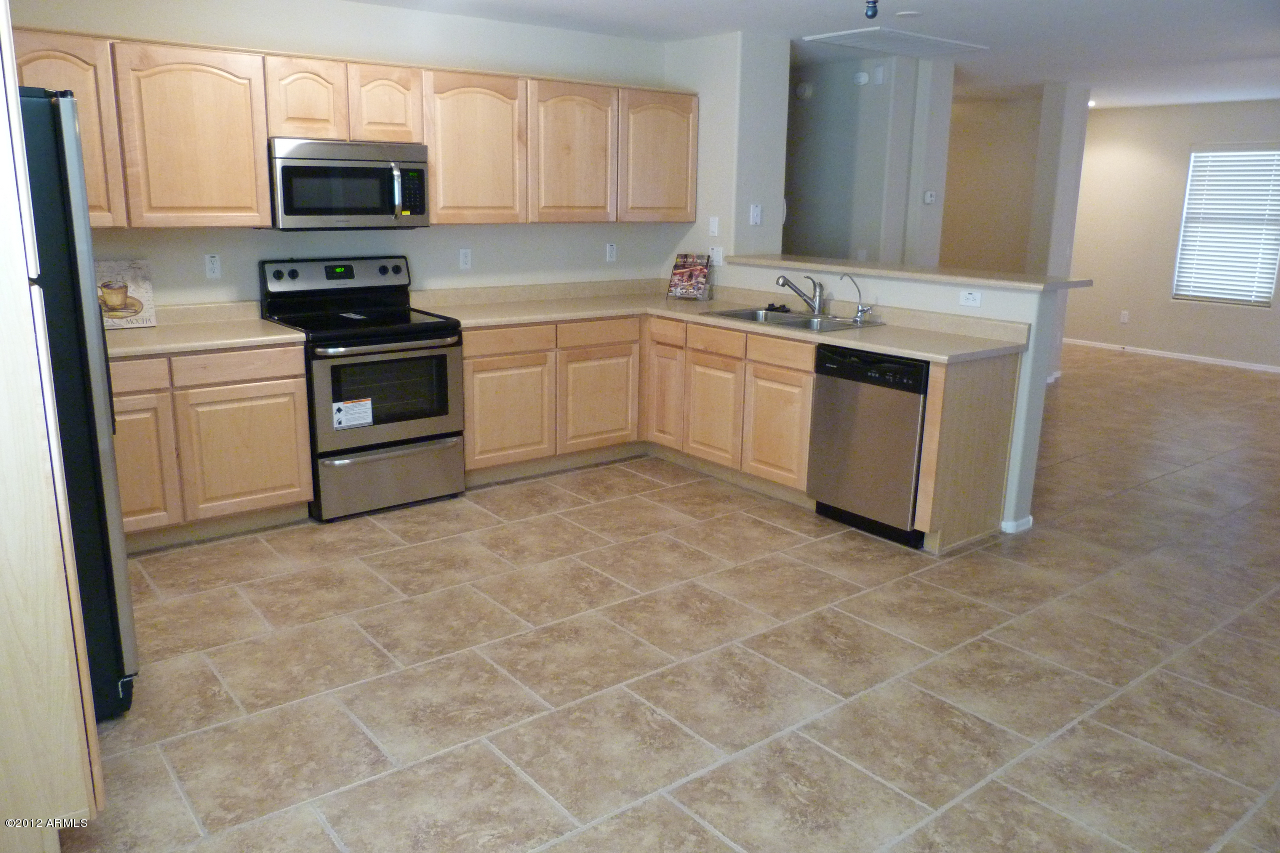 42436 West Venture Road Maricopa, AZ 85138 - Photo 3 of 28 a kitchen with stainless steel appliances granite countertop a stove top oven a sink a counter top space and cabinets