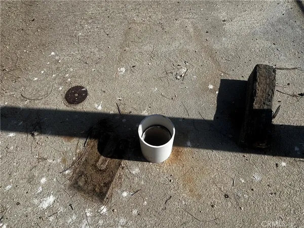 a view of a dry yard with wooden fence