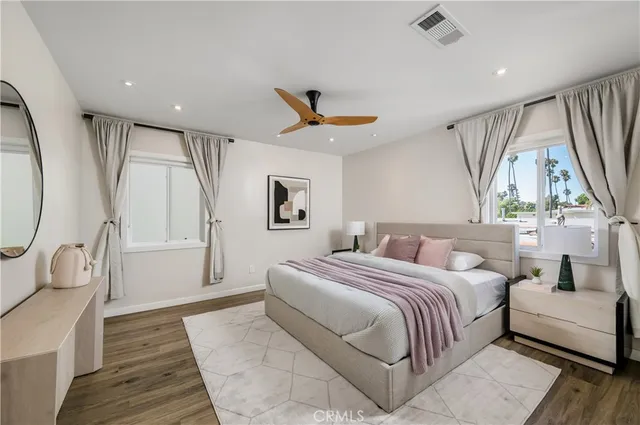 a bedroom with a bed a mirror and a window