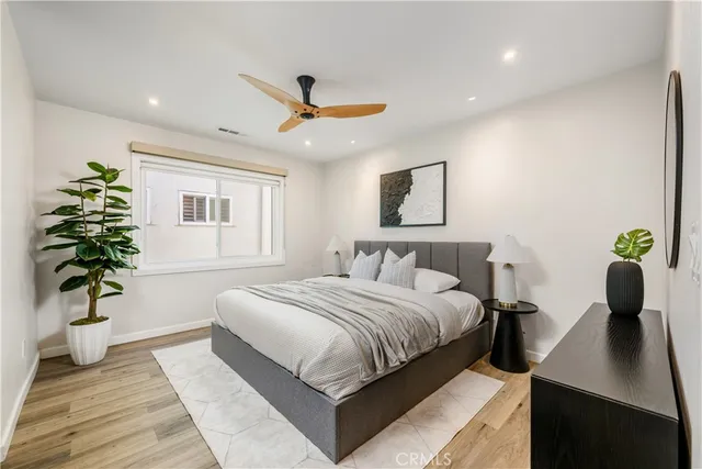a bedroom with a bed potted plant and a closet