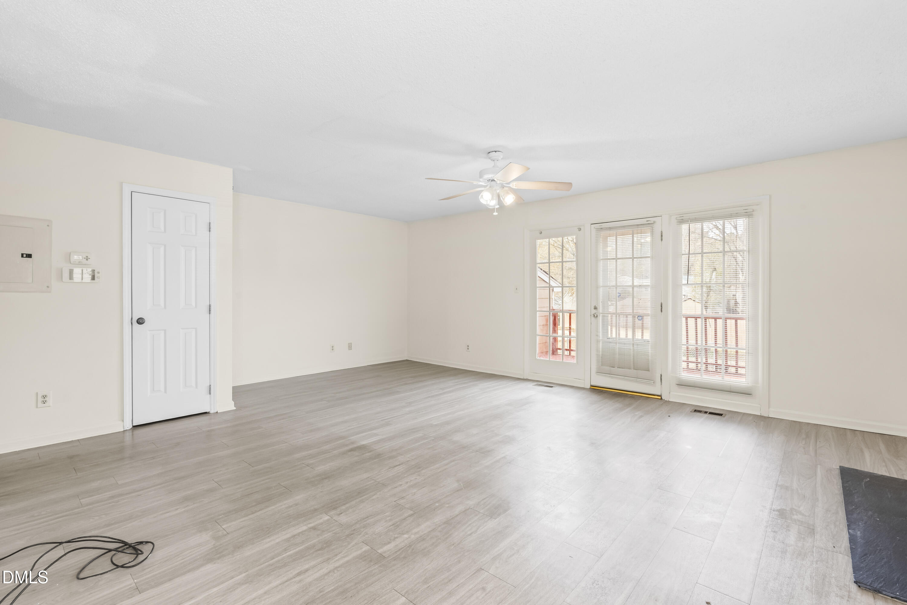 8031 Perry Creek Road Raleigh, NC 27616 - Photo 12 of 28 a view of an empty room with wooden floor and a window