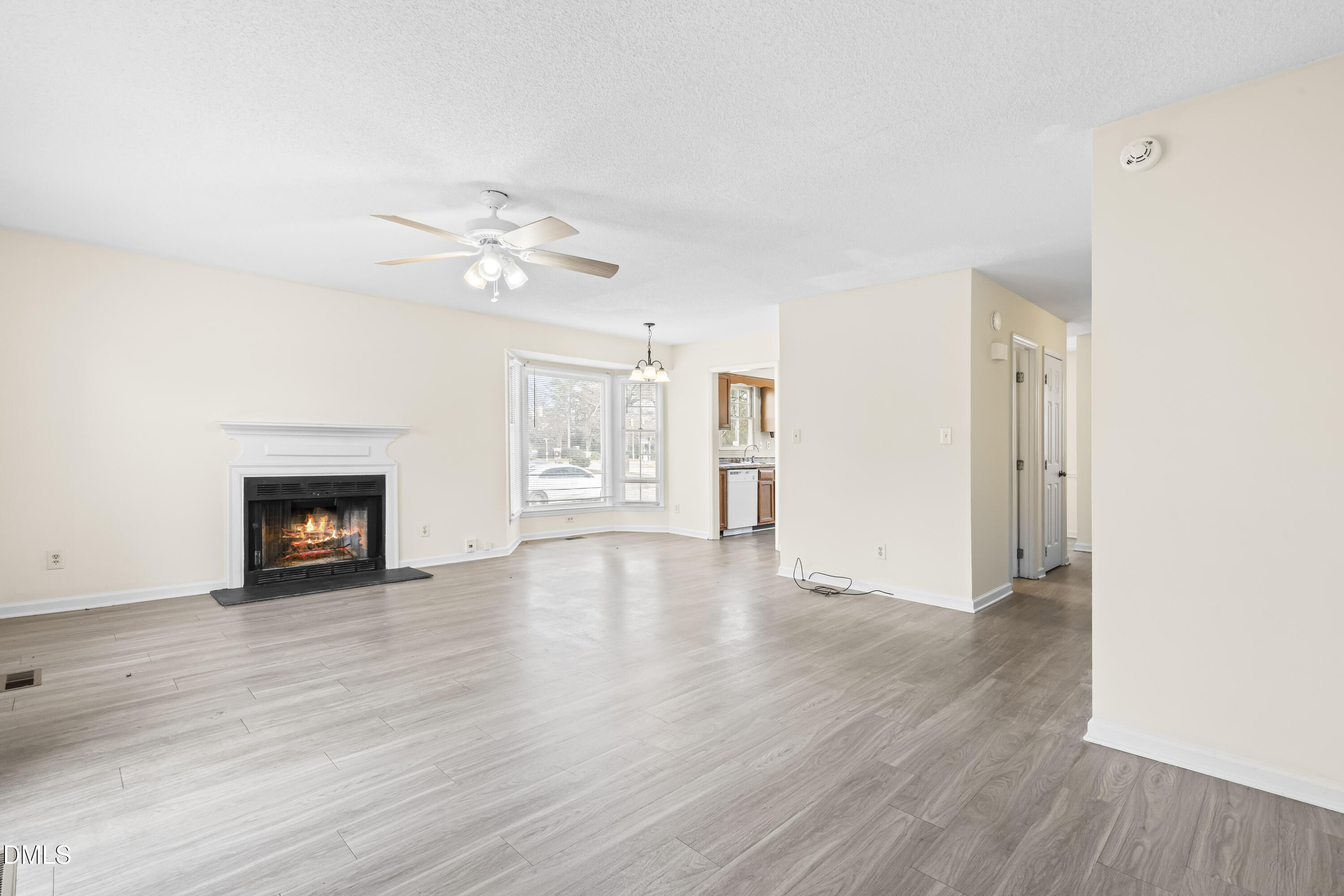8031 Perry Creek Road Raleigh, NC 27616 - Photo 13 of 28 an empty room with wooden floor a ceiling fan and a window