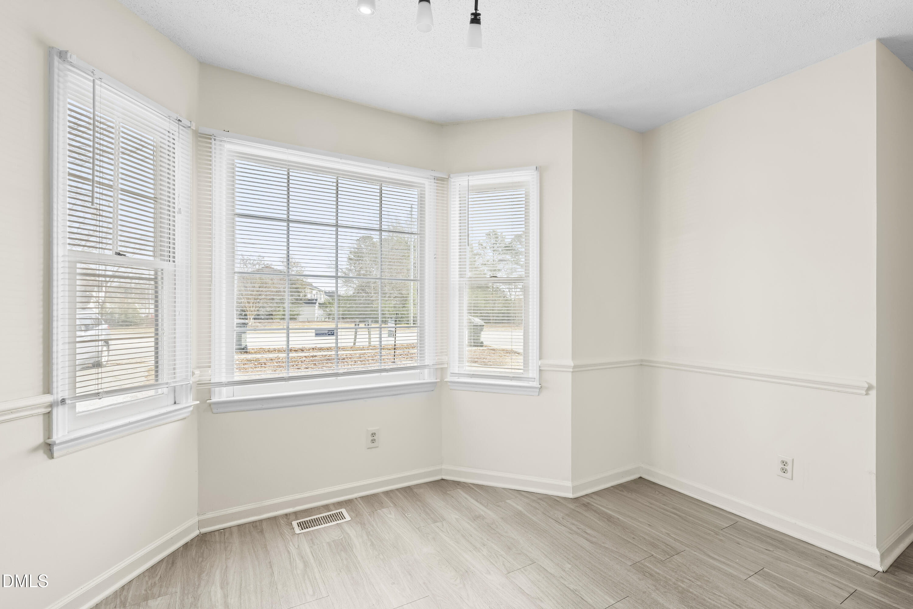 8031 Perry Creek Road Raleigh, NC 27616 - Photo 5 of 28 an empty room with wooden floor and windows