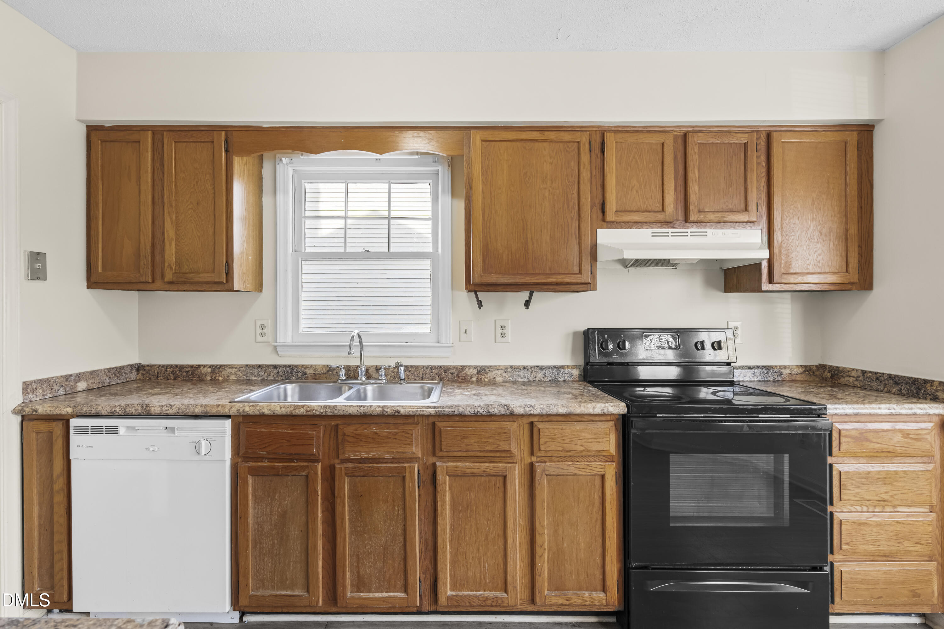 8031 Perry Creek Road Raleigh, NC 27616 - Photo 7 of 28 a kitchen with granite countertop a sink stove and cabinets