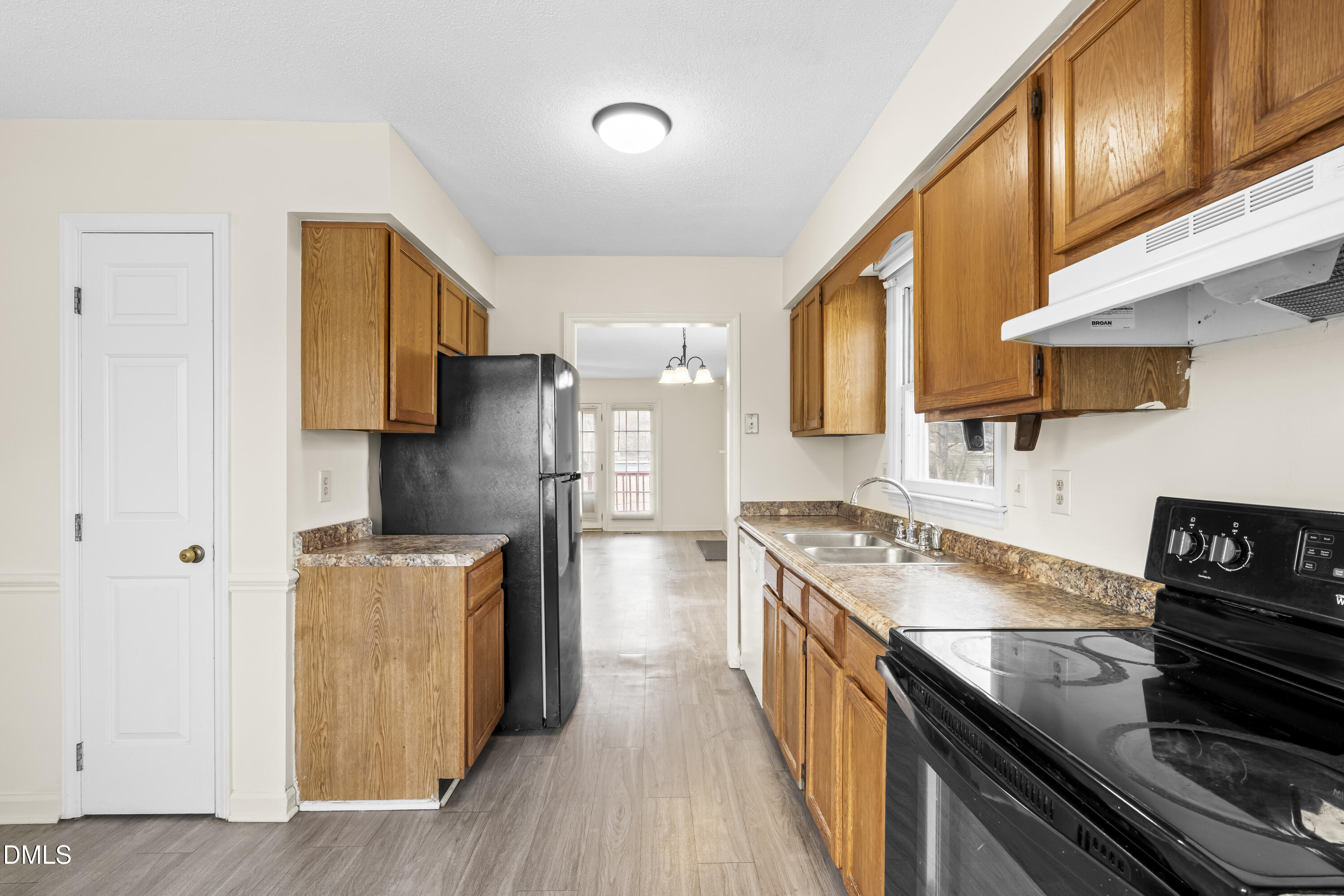 8031 Perry Creek Road Raleigh, NC 27616 - Photo 9 of 28 a kitchen with stainless steel appliances granite countertop a stove a refrigerator a sink dishwasher and wooden cabinets with wooden floor