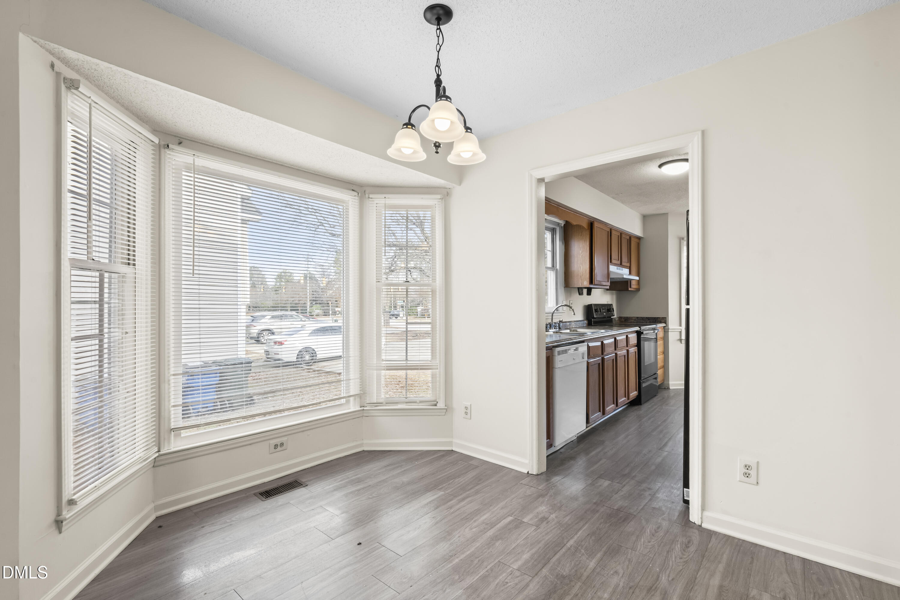 8031 Perry Creek Road Raleigh, NC 27616 - Photo 10 of 28 a view of a hallway with wooden floor and a kitchen
