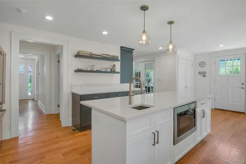 a kitchen with stainless steel appliances granite countertop a sink a stove and a wooden floors
