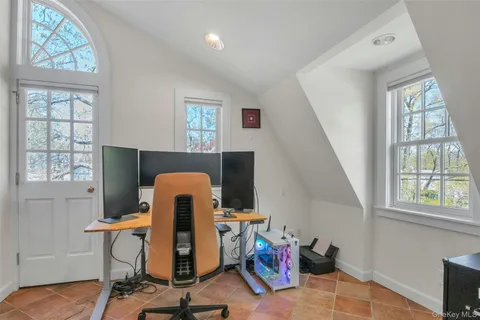 a view of a workspace with furniture and a window