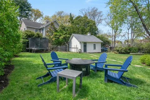 a view of a chairs and table in backyard of the house