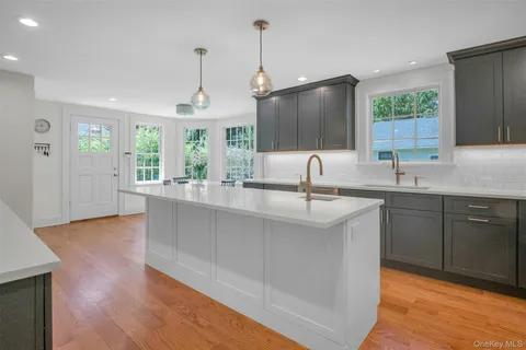 a kitchen with counter top space sink and wooden floor