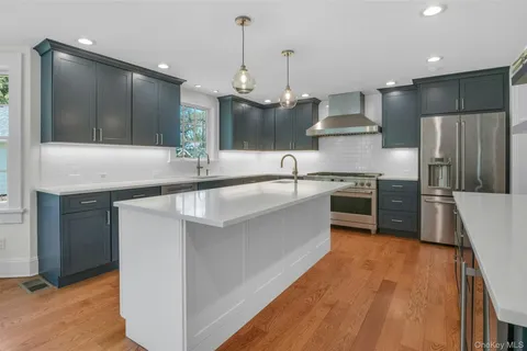 a kitchen with stainless steel appliances granite countertop a sink a stove and a refrigerator