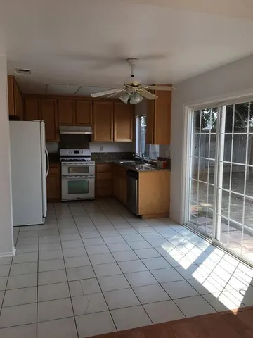a kitchen with stainless steel appliances granite countertop a stove a sink and a refrigerator