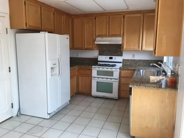 a kitchen with a refrigerator sink stove and cabinets